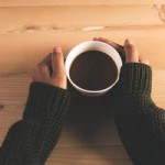 1964078-donna-mani-in-maglione-tenendo-tazza-di-caffe-su-uno-sfondo-tavolo-di-legno-foto